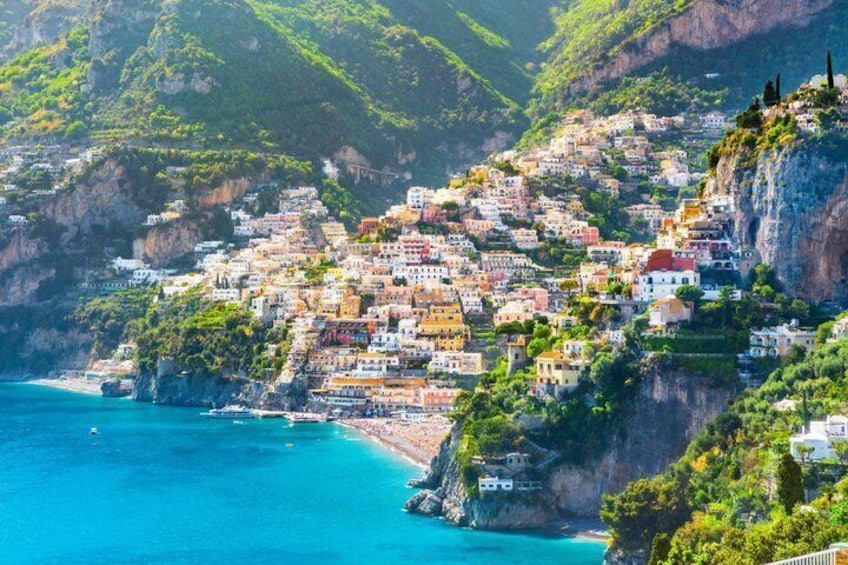 A coastal village with colorful buildings nestled on a cliff by the sea. 1