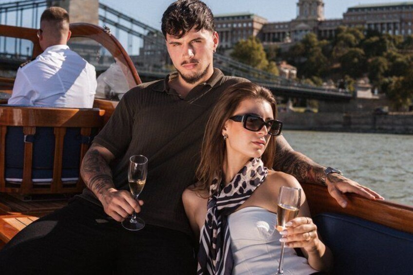 A couple on a boat with a cityscape in the background. 4