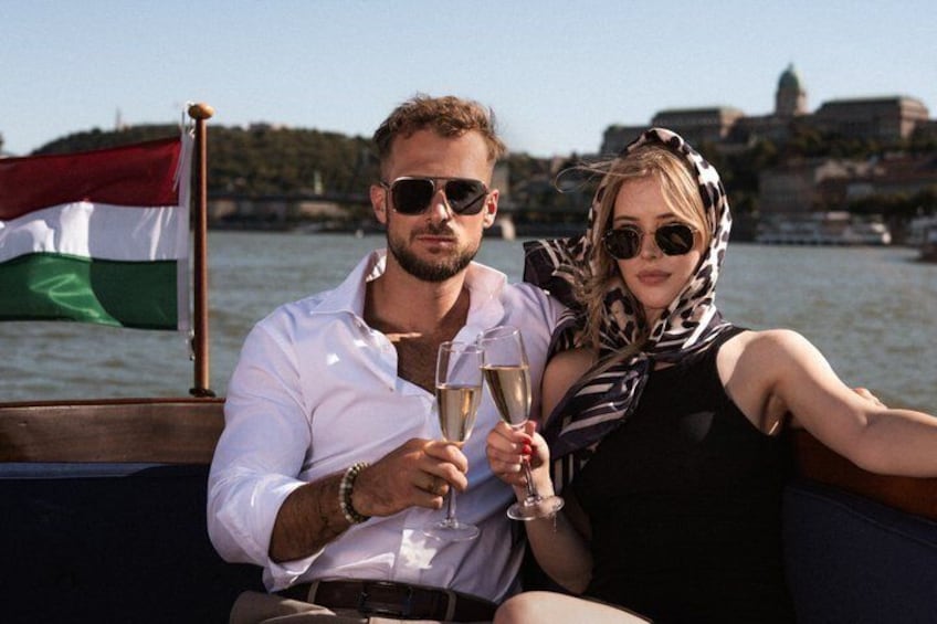 Two people on a boat with a flag in the background. 2