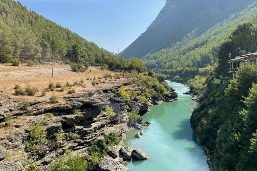 A river flowing through a rocky gorge with dense forest on either side. 2