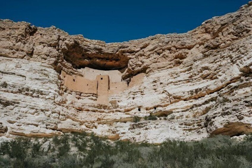 A rock formation with a cave entrance and a vertical shaft. 3