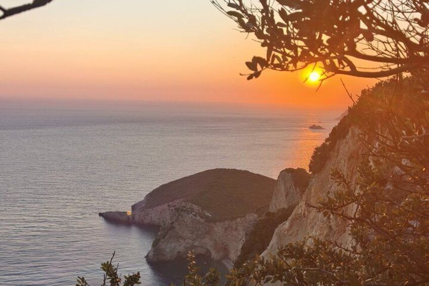 A sunset over a coastal landscape with rocky cliffs and calm sea. 5