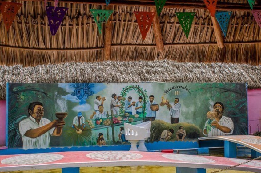 A mural with a tropical scene, a thatched roof, and colorful triangular flags. 5
