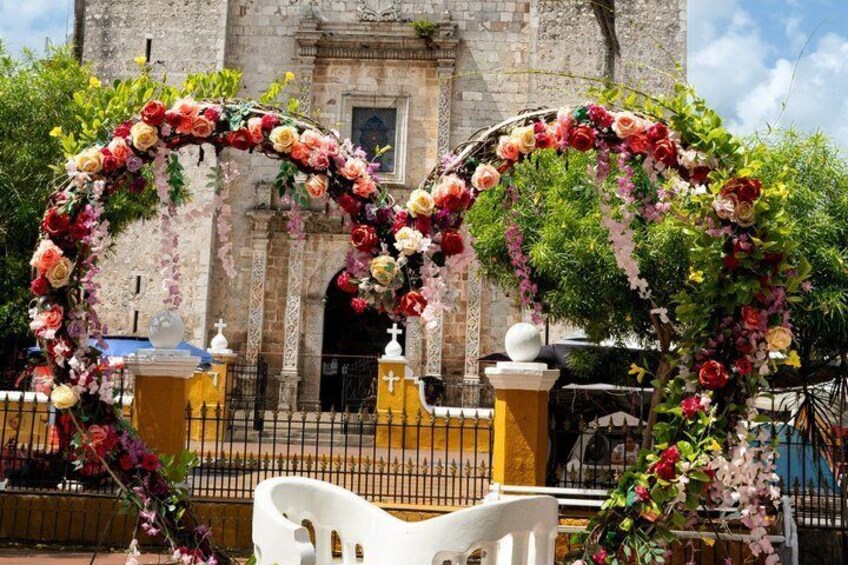 A heart-shaped floral archway in front of a historic building. 2