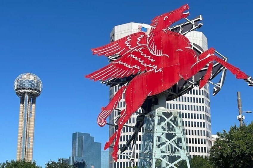 A red dragon sculpture, a tower, and modern buildings. 1