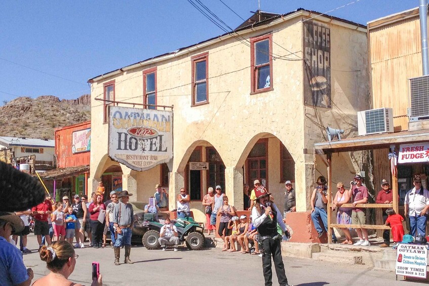 A street scene with a hotel, a sign for 'Oatman Hotel,' and a crowd of people. 3