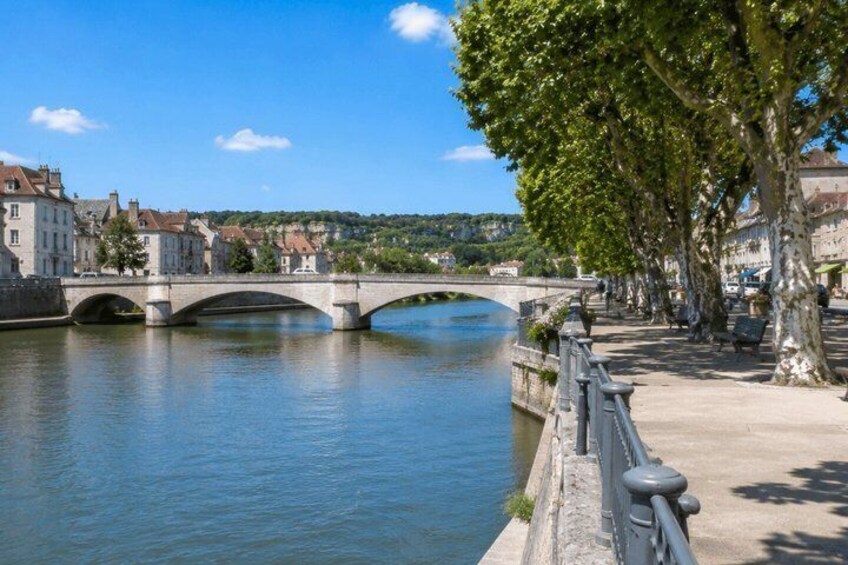 A stone bridge over a river, lined with trees and buildings. 2