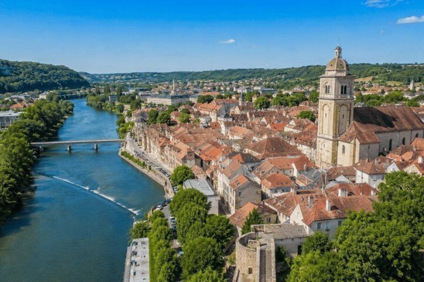 A river flowing through a town with historic buildings and a prominent tower. 1