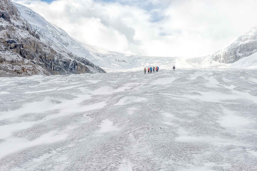 A group of people hiking on a snow-covered glacier. 2