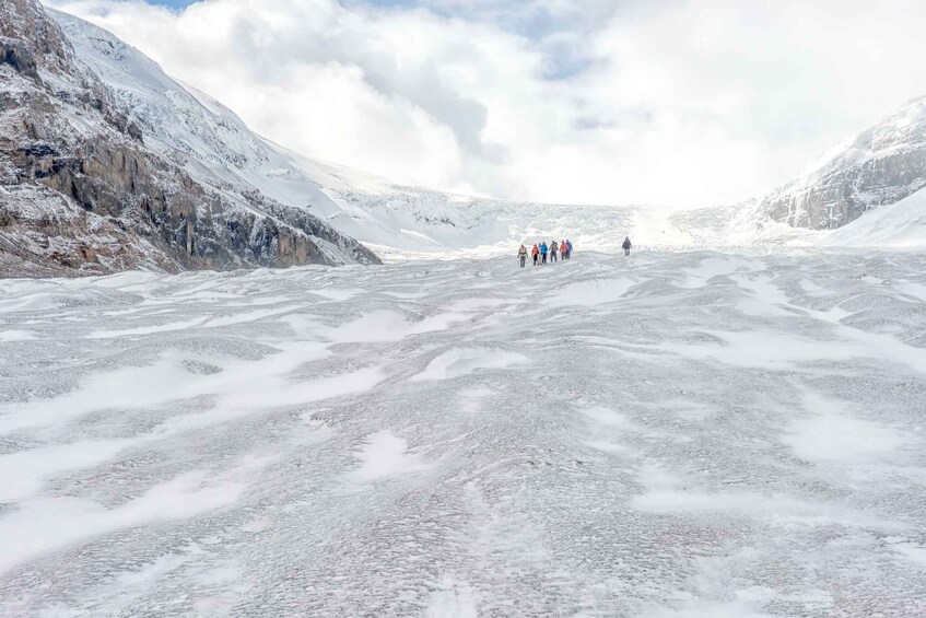 A glacier with a group of people walking on it. 3