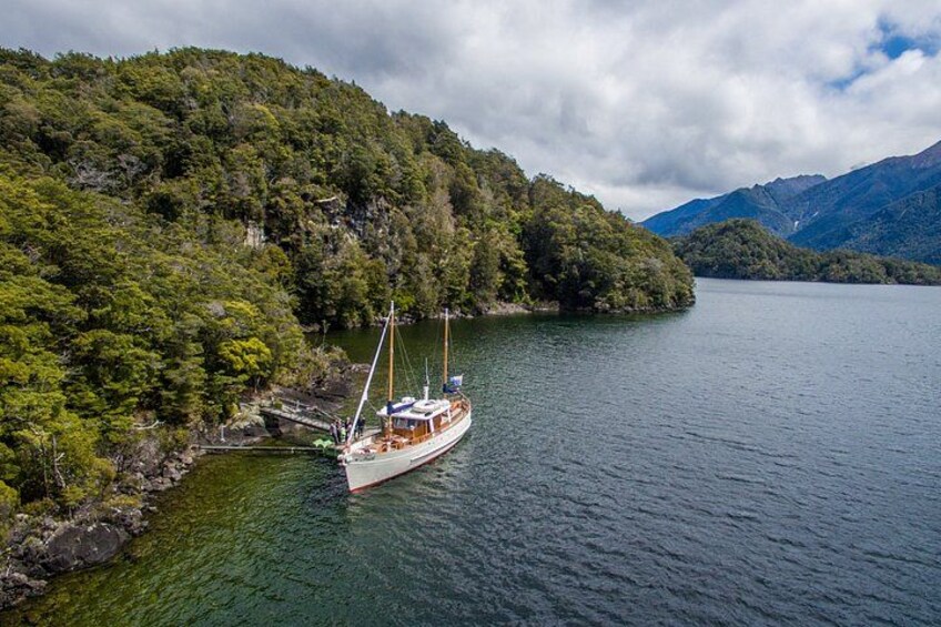 A boat on a calm lake surrounded by lush green hills. 2