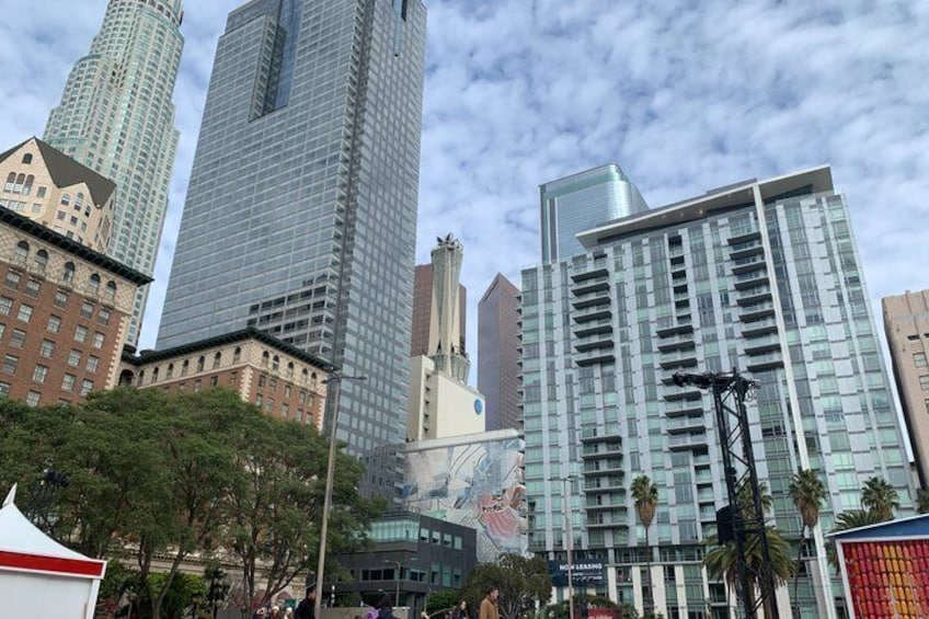 A cityscape with tall buildings, including a prominent glass skyscraper and a historic brick building. 3
