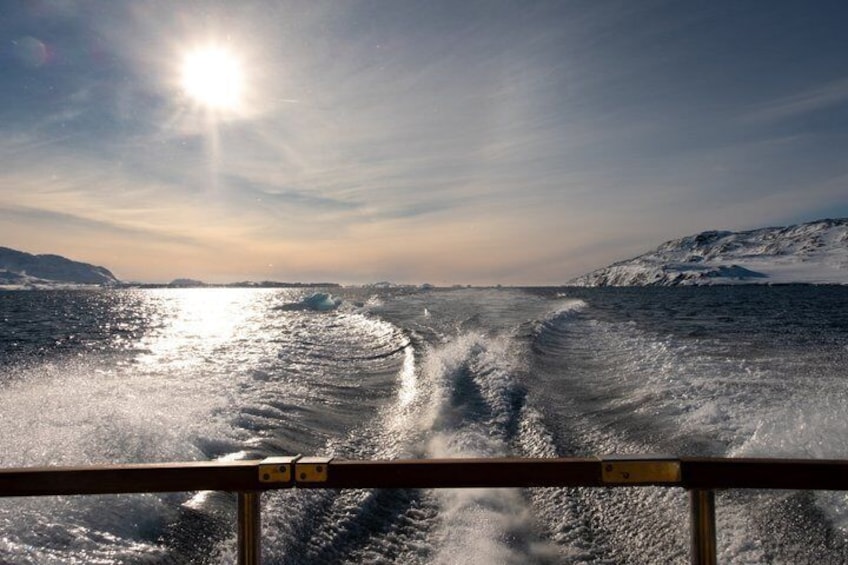 A ship's wake in a snowy landscape with the sun shining. 3