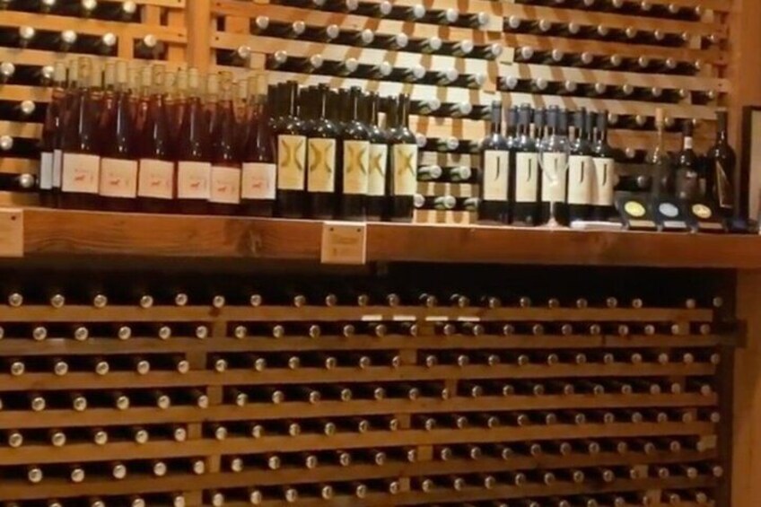 A wine cellar with wooden racks holding bottles of wine. 5