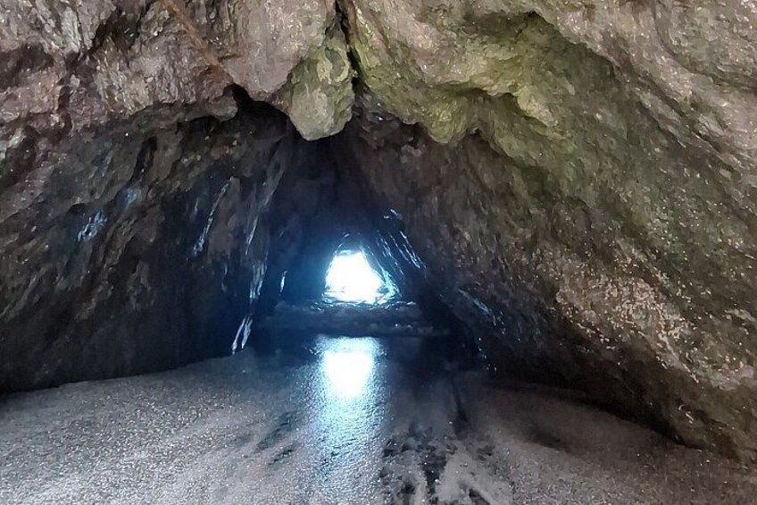 A cave with a narrow passage leading to a brighter area. 5