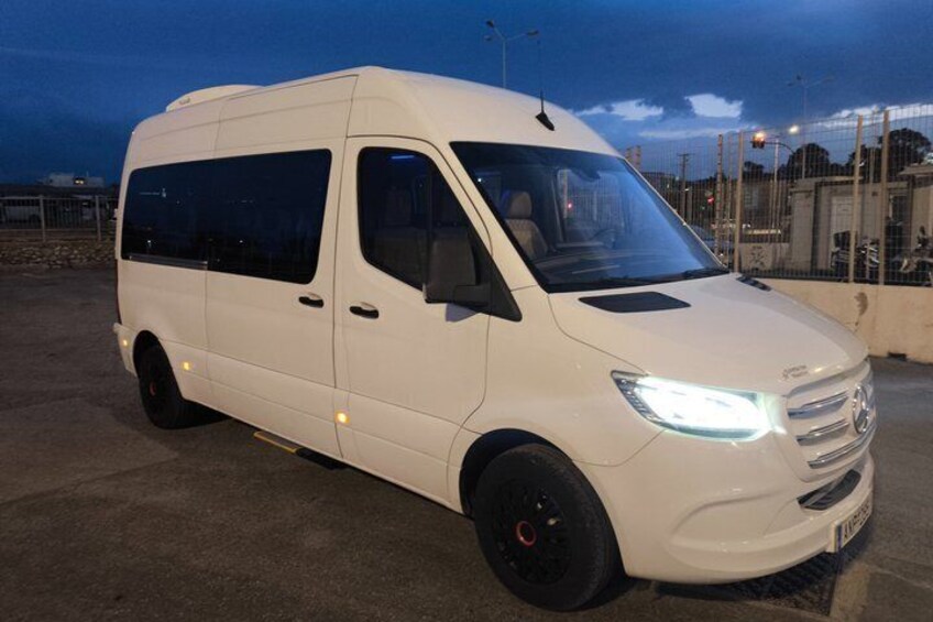 A white van parked on a concrete surface at dusk. 3