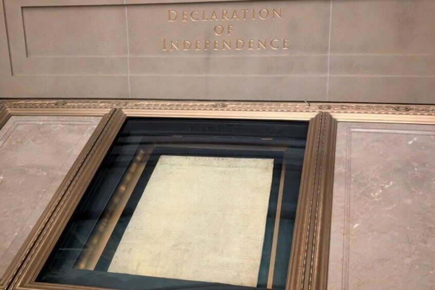 A framed historical document titled 'Declaration of Independence' in a museum setting. 2