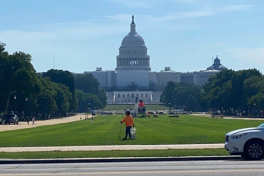 The United States Capitol building, a grassy lawn, and a person with a walking stick. 4