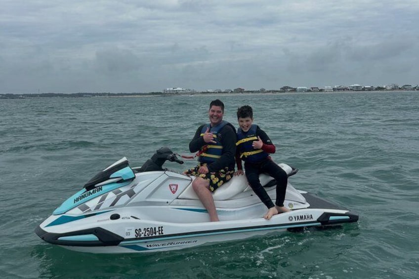 Two people on a Yamaha jet ski in the water. 4