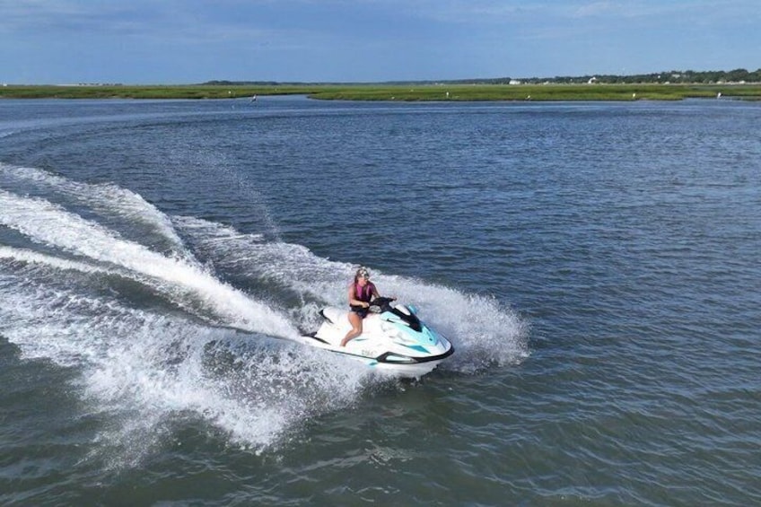 A person jet-skiing on a body of water with waves created by the jet ski. 1