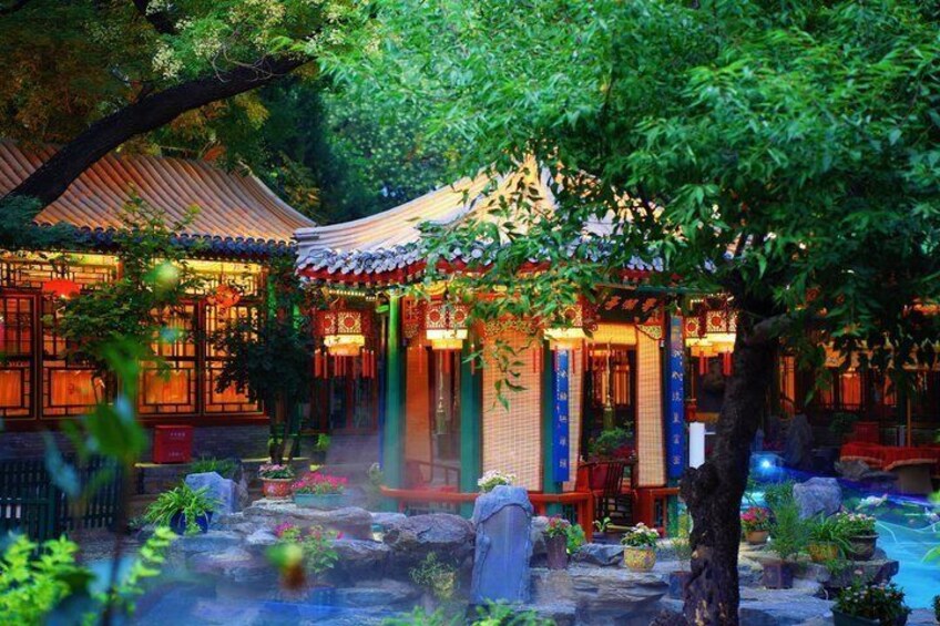 A traditional Chinese courtyard with a tiled roof, wooden structures, and a koi pond. 3