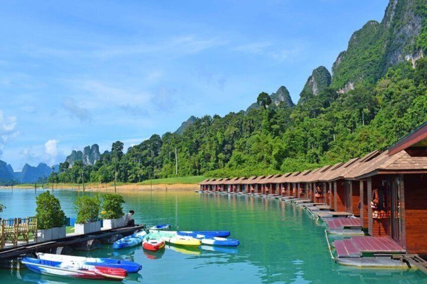 A waterfront resort with overwater bungalows and colorful boats. 1