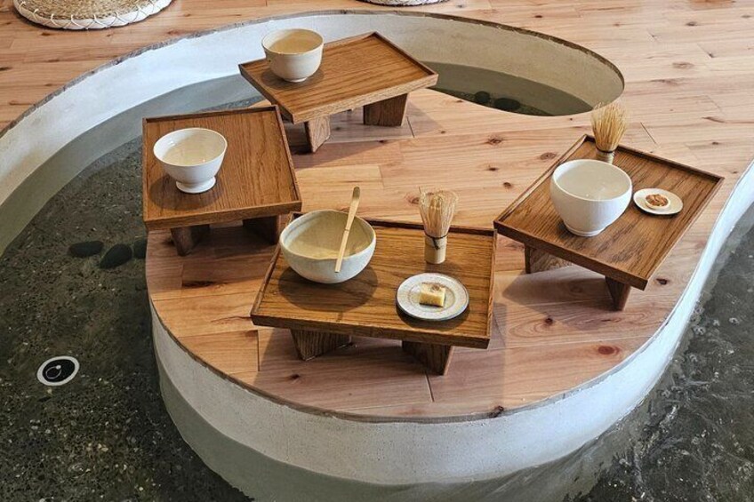 A wooden table set with bowls and chopsticks on a circular platform. 1