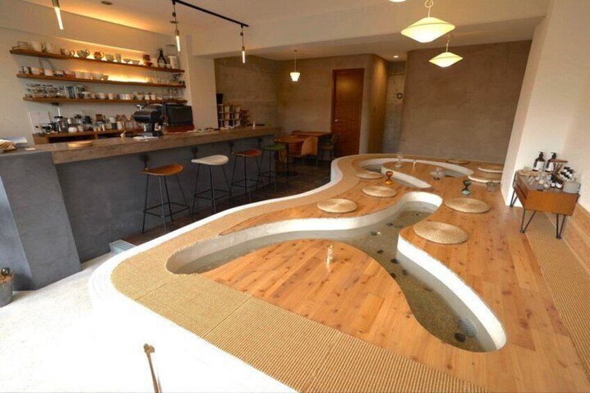 A modern bar area with a unique curved counter, stools, and a bar stocked with bottles. 1