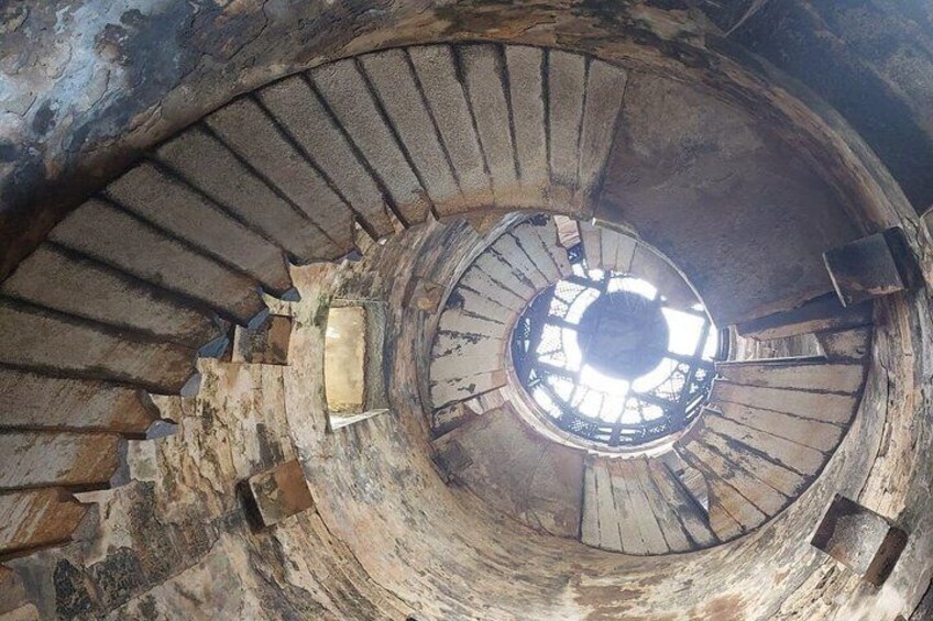 A spiral staircase with a skylight at the top. 2