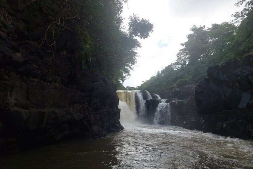 A waterfall cascading over rocks in a forested area. 3