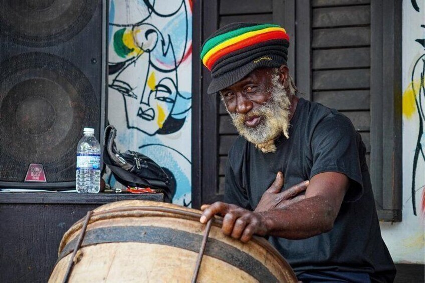 A person playing a drum, a water bottle, and a bag on a table. 2