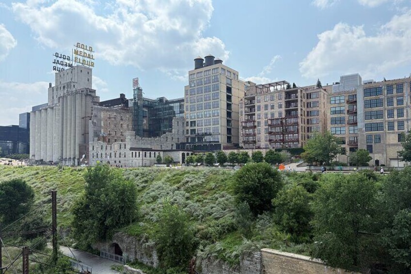 A cityscape with industrial buildings, a park, and a clear sky. 5