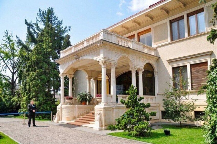 A classical building with a portico, steps, and a well-maintained lawn. 1