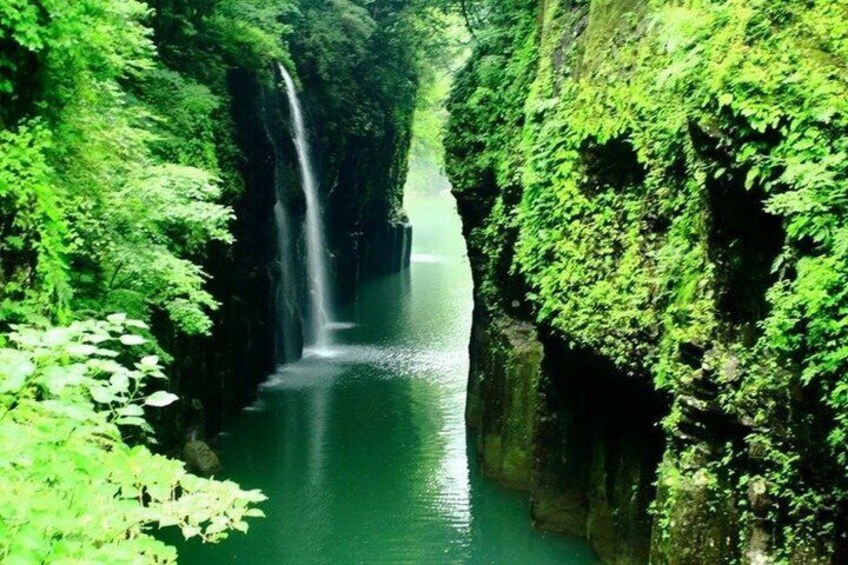 A waterfall in a lush green canyon. 4