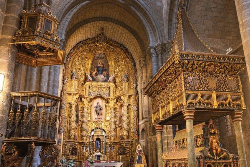 An ornate church interior with a central altar, a golden canopy, and intricate stone carvings. 3