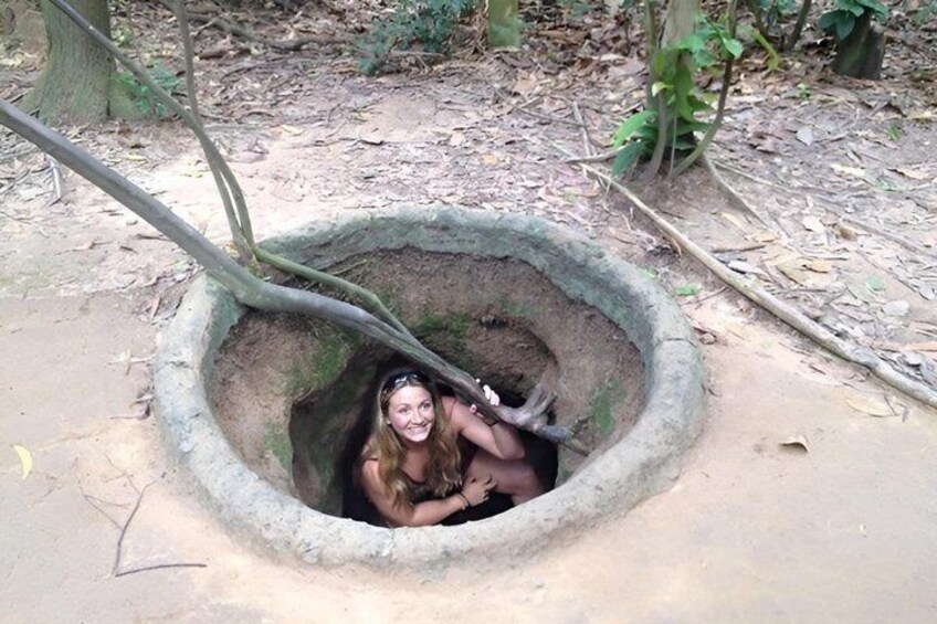 A person sitting inside a circular stone structure in a forest. 3