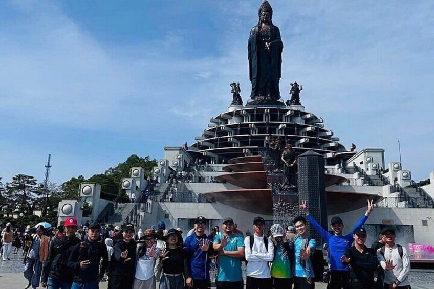 A large statue with multiple tiers, surrounded by a crowd of people. 4