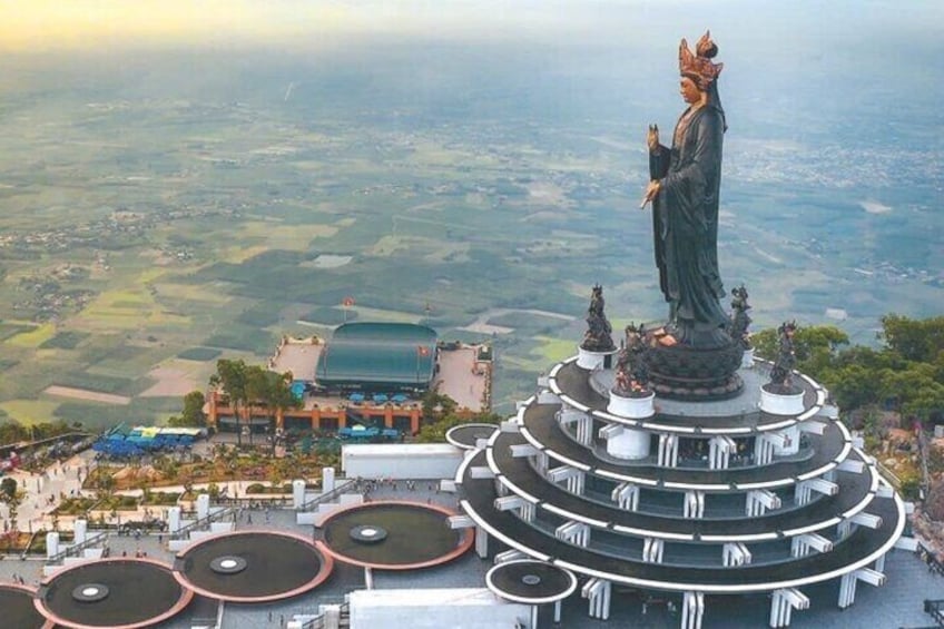 A statue on a circular platform with a panoramic view of a valley. 1