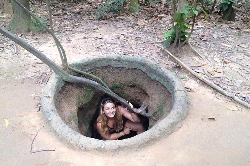 A person sitting inside a circular stone structure in a forest. 2