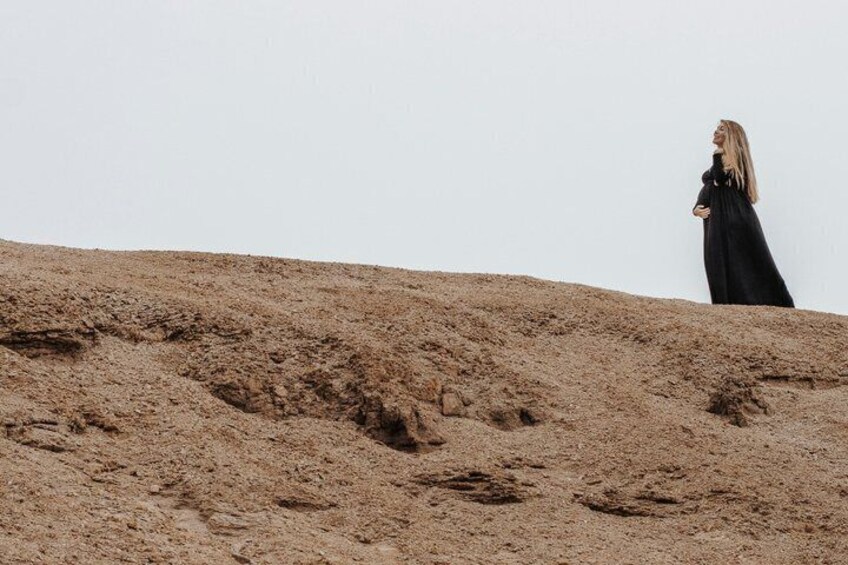 A person standing on a sandy hill with a clear sky. 3