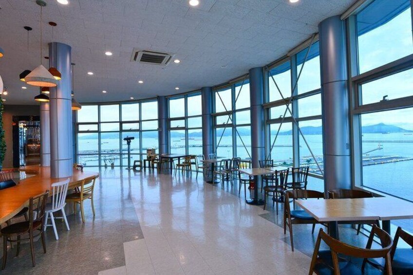 A spacious indoor area with large windows overlooking a body of water. 5