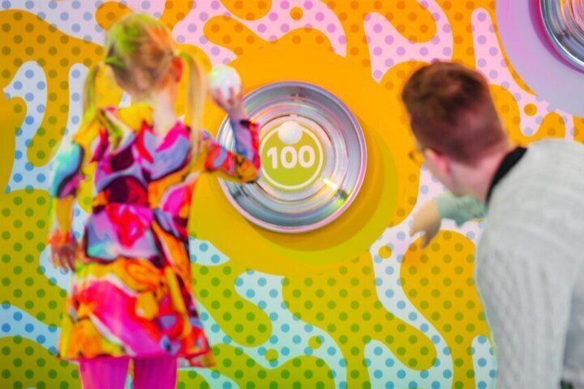 A colorful, polka-dotted wall with a target-like design and the number 100. 2