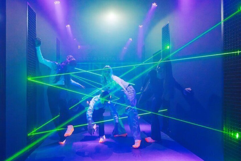 A dance performance with laser lights in a dimly lit room. 1