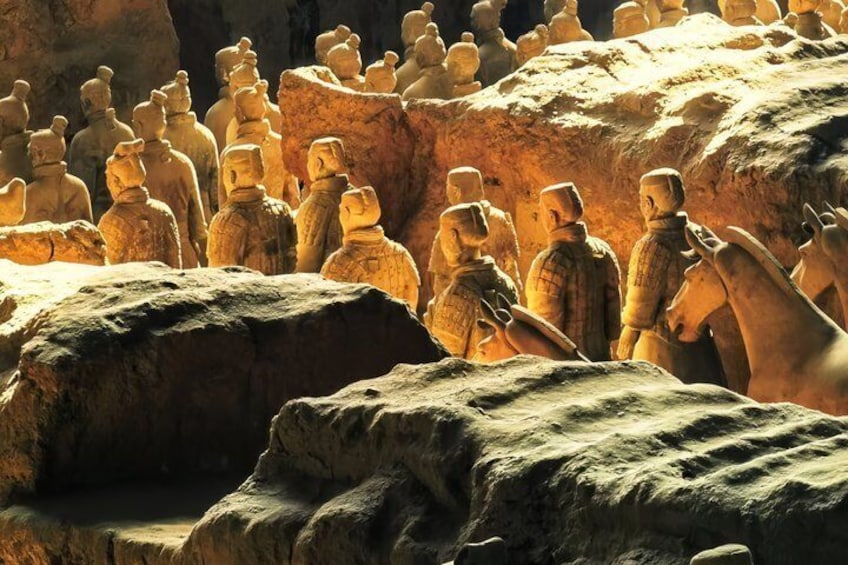 Terracotta soldiers in a formation, standing on rocky terrain. 1
