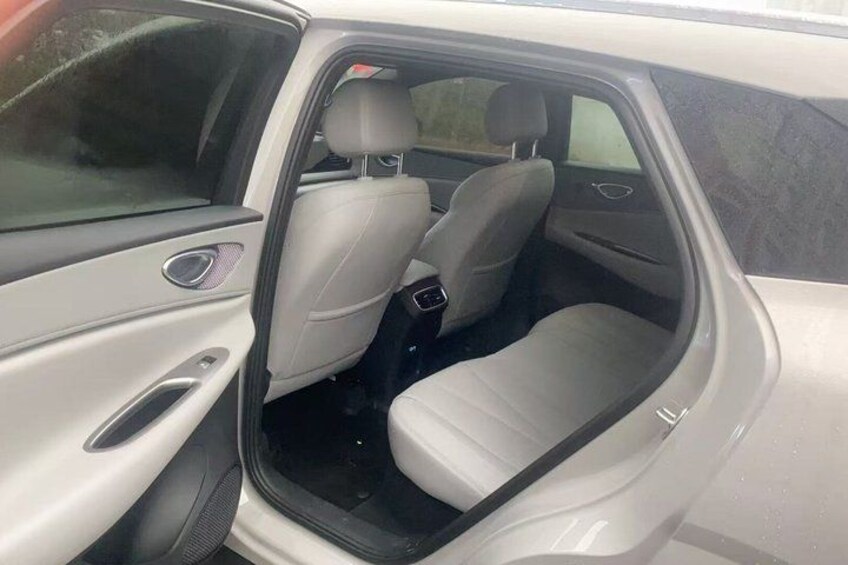 A car's interior with beige leather seats and a visible door handle. 2