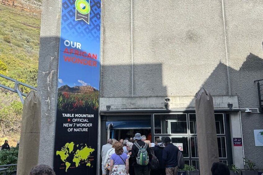 A building entrance with a banner reading 'OUR AFRICAN WONDER' and 'TABLE MOUNTAIN OFFICIAL NEW 7 WONDER OF NATURE.' 4