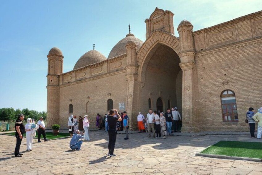 A historical building with arches and domes, surrounded by tourists. 4