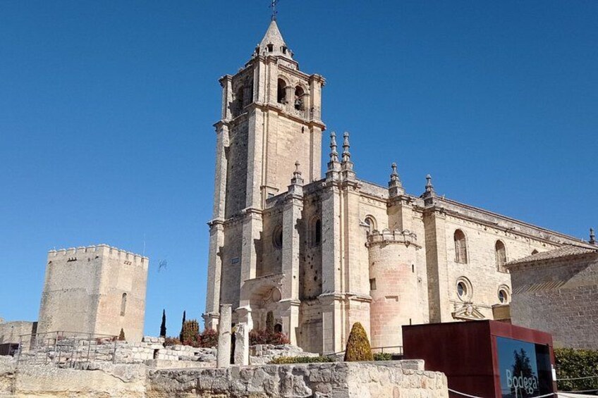 A historic church with a bell tower and a nearby fortification. 3