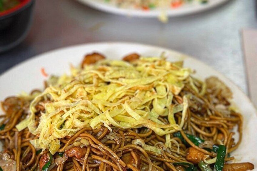 A plate of stir-fried noodles with vegetables and possibly meat. 2