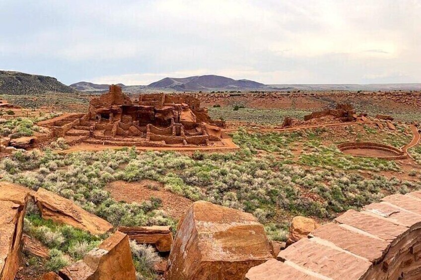 Ancient ruins in a desert landscape with sparse vegetation. 5